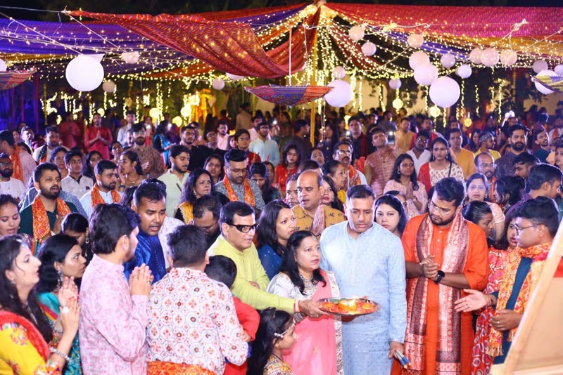 A dense crowd gathered around the aarti thali beneath strings of fairy lights and paper lanterns.